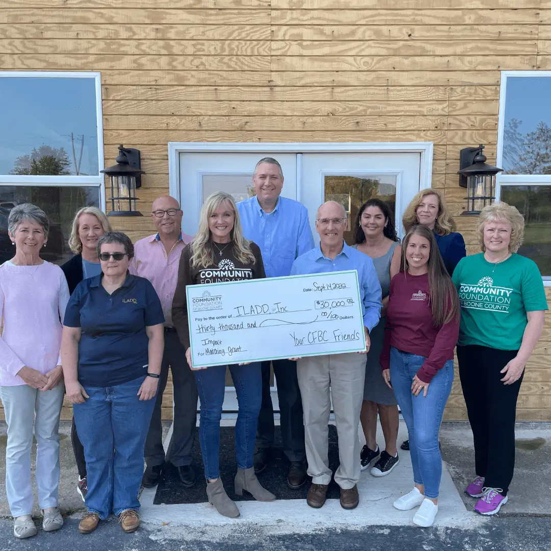 Group of people receiving donation cheque with happy faces